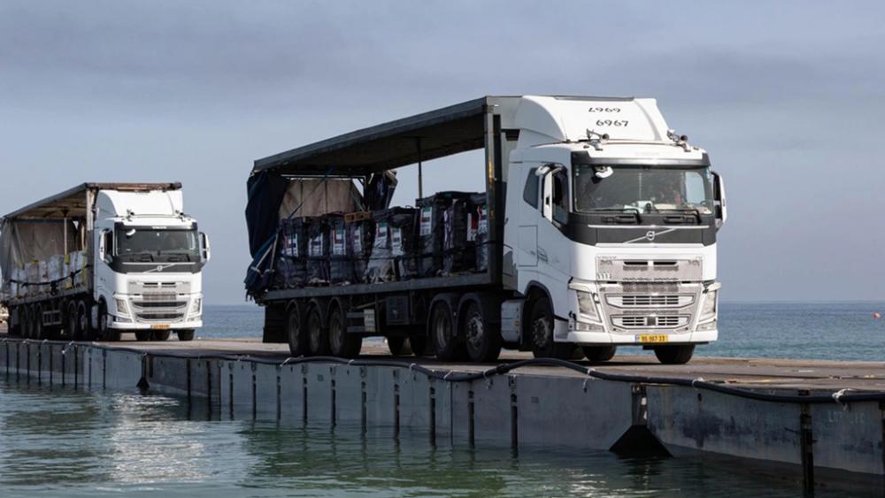 Trucks loaded with humanitarian aid from the United Arab Emirates and the United States Agency for International Development cross the Trident Pier before entering the beach in Gaza, May 17, 2024. (Staff Sgt. Malcolm Cohens-Ashley/U.S. Army Central via AP