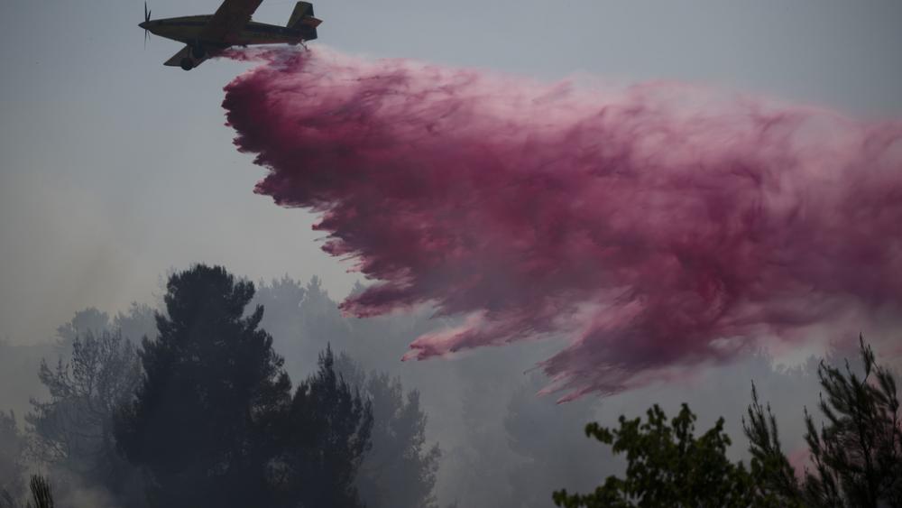 A plane uses a fire retardant to extinguish a fire burning in an area near the border with Lebanon, in Safed, northern Israel, Wednesday, June 12, 2024. (AP Photo/Leo Correa)