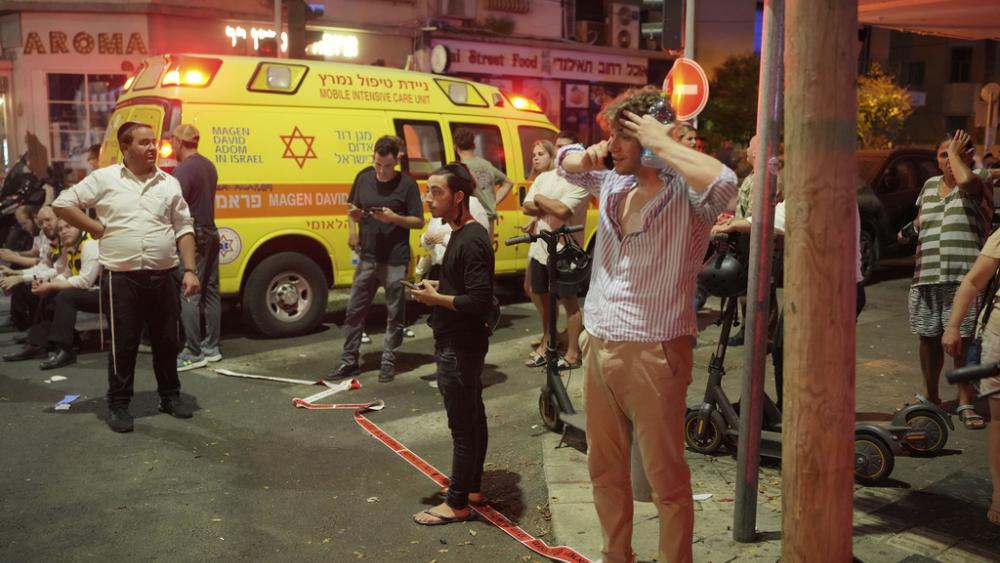 People gather at the scene of an deadly explosion in Tel Aviv, Israel, early Friday, July 19, 2024. (AP Photo/Erik Marmor)