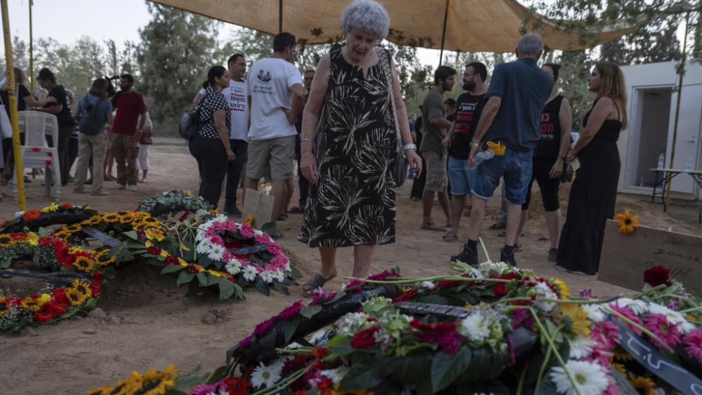 Widow Ruti Munder stands near the grave of her husband Avraham Munder, who was killed in Hamas captivity in the Gaza Strip and recovered by the Israeli military in Gaza, at Kibbutz Nir Oz, Wednesday, Aug. 21, 2024. (AP Photo/Ohad Zwigenberg)