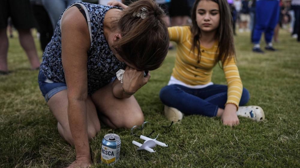 Brandy Rickaba and her daughter Emilie pray during a candlelight vigil for the slain students and teachers at Apalachee High School, Wednesday, Sept. 4, 2024, in Winder, Ga. (AP Photo/Mike Stewart)