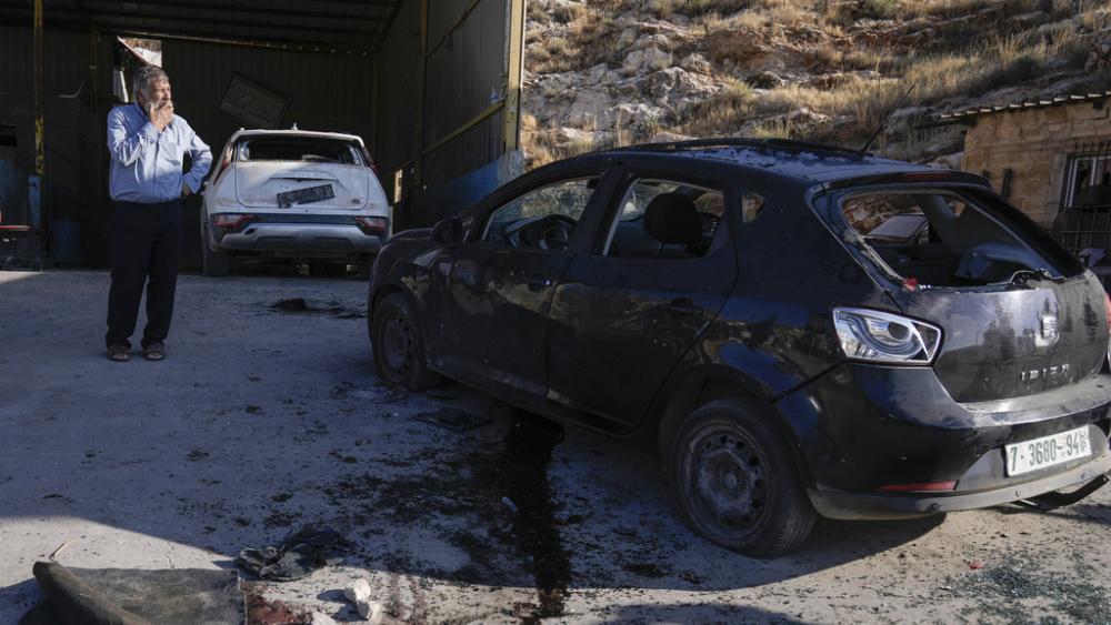 Palestinians look at a damaged car following an Israeli airstrike in Tubas, West Bank, Thursday, Sept. 5, 2024. (AP Photo/Majdi Mohammed)