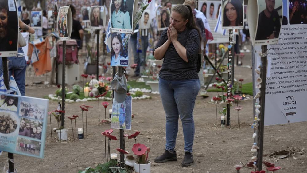 Victoria stands in front a picture of her sister, Yulia Waxer Daunt, as she visits the site of the Nova music festival, where hundreds of revelers were killed and abducted by Hamas, Monday, Oct. 7, 2024. (AP Photo/Ariel Schalit)