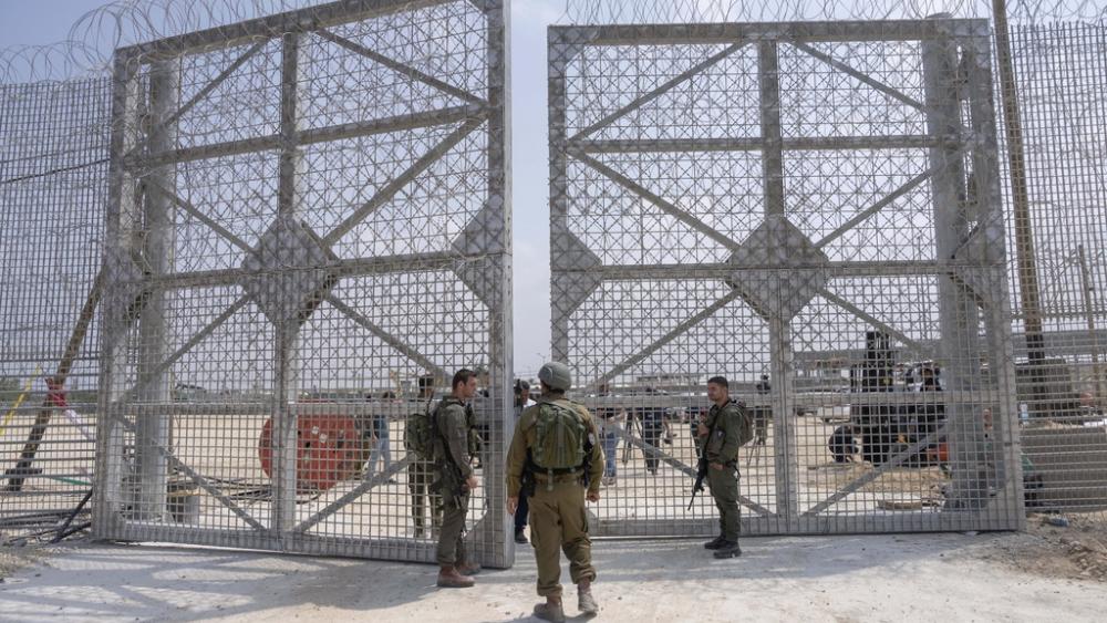 Israeli soldiers gather near a gate to walk through an inspection area for trucks carrying humanitarian aid supplies bound for the Gaza Strip, on the Israeli side of the Erez crossing into northern Gaza, on May 1, 2024. (AP Photo/Ohad Zwigenberg, File)