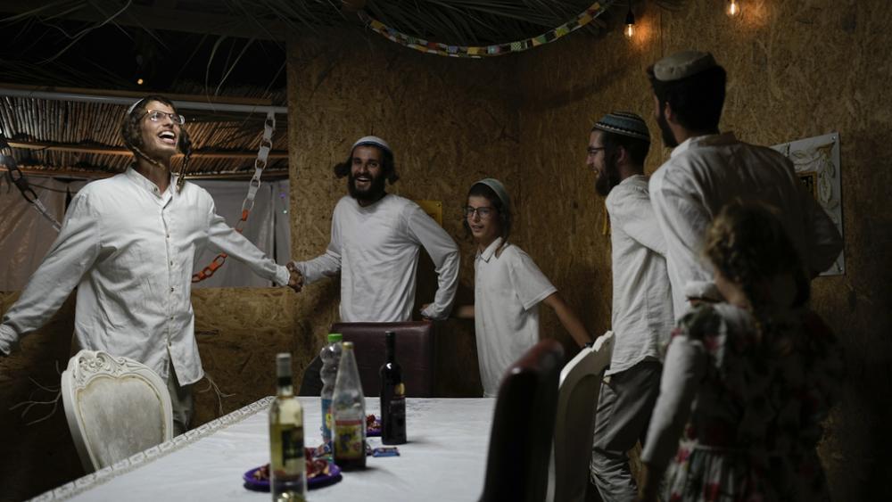 Israelis celebrate the news of the death of Hamas leader Yahya Sinwar, near Kibbutz Erez, southern Israel, on Thursday, Oct. 17, 2024, (AP Photo/Tsafrir Abayov)