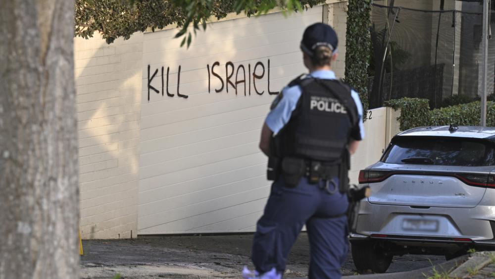 A police officer stands near where anti-Israel graffiti is painted on a wall in Sydney, Australia, on Dec. 11, 2024. (Mick Tsikas/AAP Image via AP)