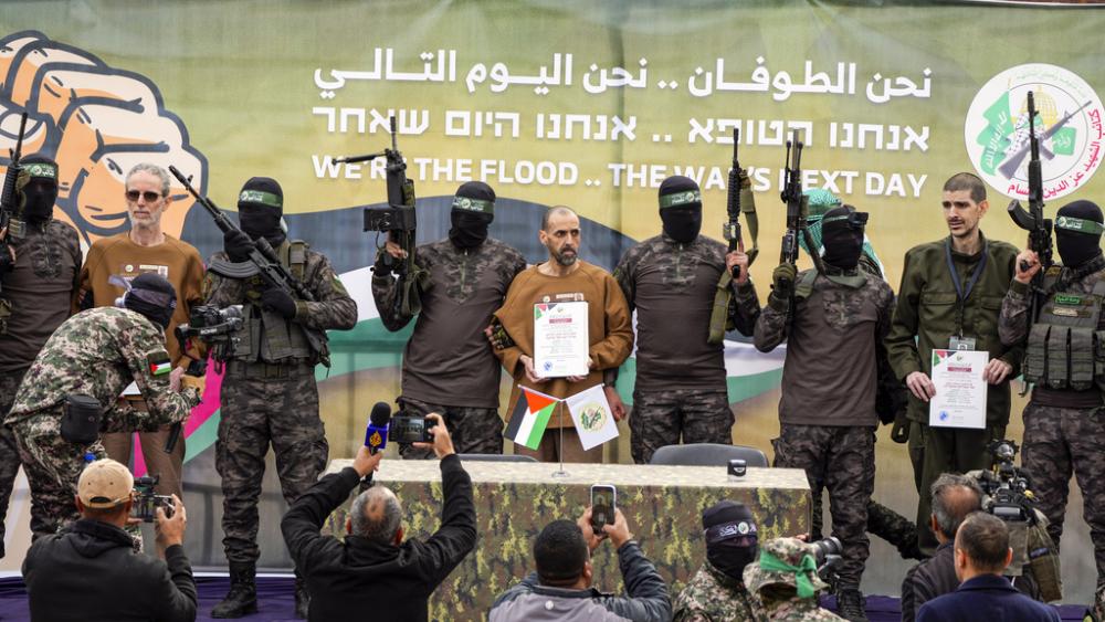 Israeli captives, from left to the right, Ohad Ben Ami, Eli Sharabi and Or Levy, who have been held hostage by Hamas in Gaza since October 7, 2023, escorted by Hamas fighters in the central Gaza Strip, Feb. 8, 2025. (AP Photo/Abdel Kareem Hana)