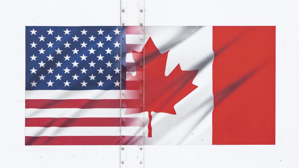 U.S. and Canada flags are seen on a transport truck trailer at the Pacific Highway Canada-U.S. border crossing in Surrey, British Columbia, on Tuesday, March 4, 2025. (Ethan Cairns/The Canadian Press via AP)
