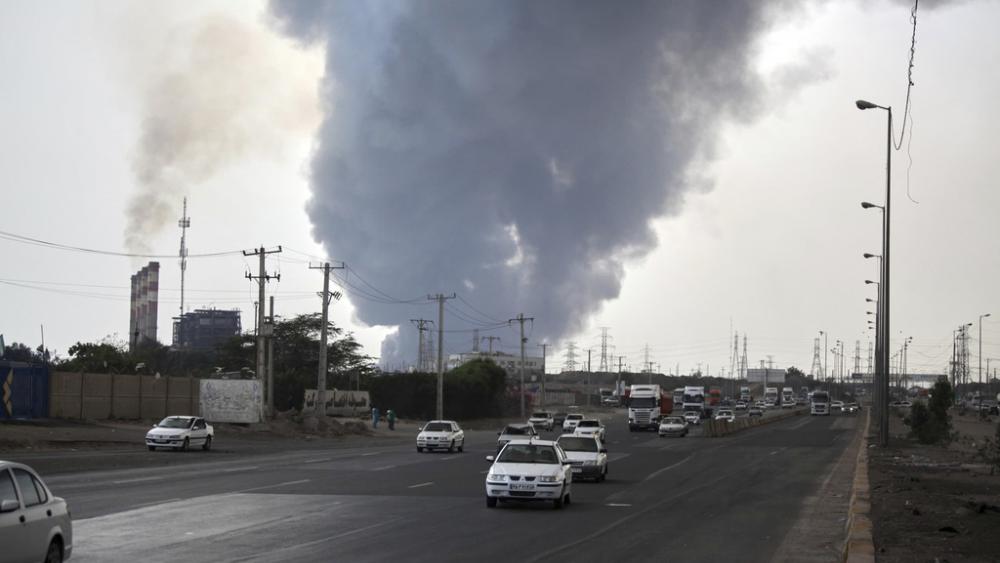 In this photo provided by Islamic Republic News Agency, IRNA, a black smoke rises in the sky as vehicles drive on the road after a massive explosion near the southern port city of Bandar Abbas, Iran, April 26, 2025. (Mohammad Rasoul Moradi/IRNA) 