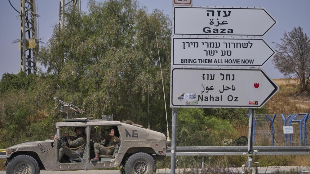 Israeli army vehicle passes by a new sign pointing towards Gaza reading &quot;To release Omri Miron go straight&quot; near Kibbutz Nahal Oz in southern Israel, where Miron was kidnapped from on Oct. 7, on Sunday, June 1, 2025. (AP Photo/Ohad Zwigenberg)