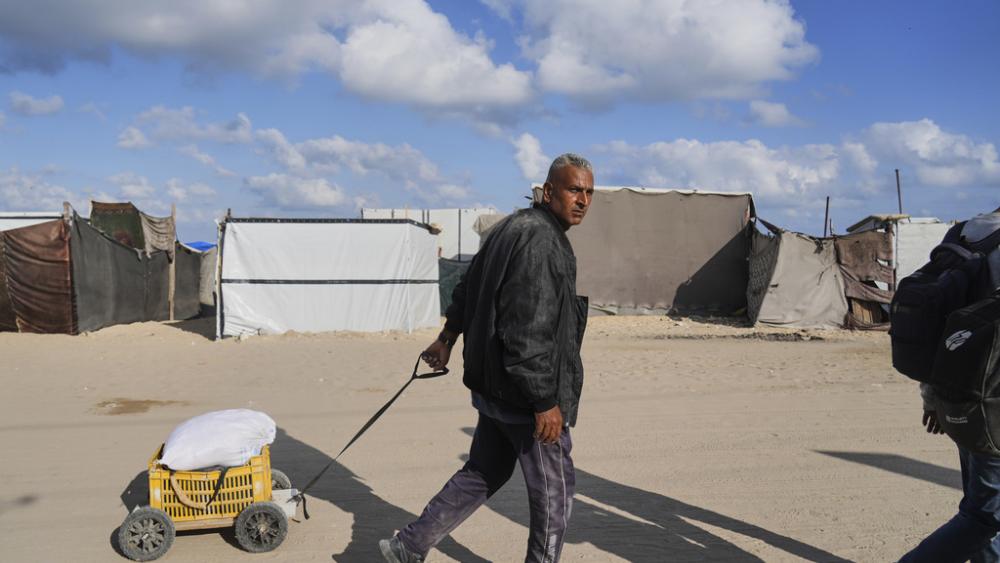 Palestinians carry bags filled with food and humanitarian aid provided by the Gaza Humanitarian Foundation, a U.S.-backed organization approved by Israel, in Khan Younis, southern Gaza Strip, on Tuesday, June 3, 2025. (AP Photo/Abdel Kareem Hana)
