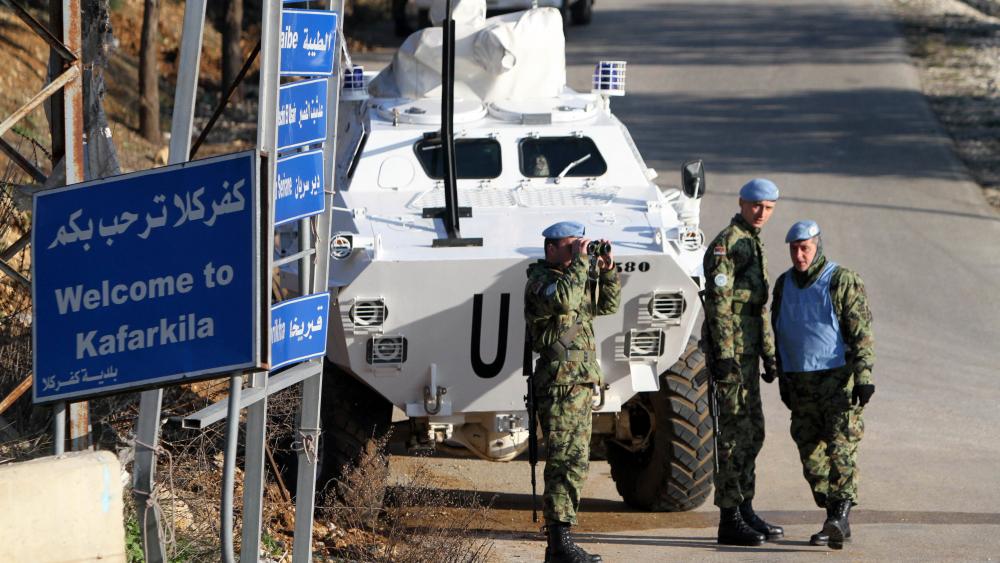 A Serbian U.N. peacekeeper looks through binoculars to monitor the border with Israel during a patrol of the Lebanese-Israeli border, in the southern village of Kfar Kila, Lebanon, Monday, Jan. 19, 2015. (AP Photo Mohammed Zaatari)