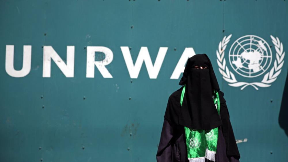 FILE: A Palestinian woman wears a green Hamas scarf attends a demonstration against a U.N. Relief and Works Agency (UNRWA) funding gap, August 16, 2015. (AP Photo/Khalil Hamra)