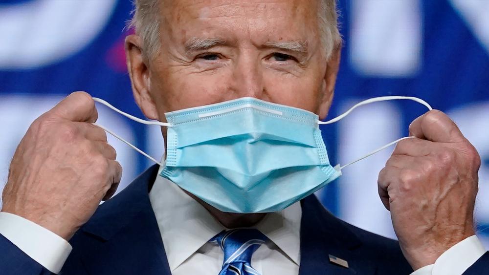 Democratic presidential candidate former Vice President Joe Biden takes off his face mask. (AP Photo/Carolyn Kaster)