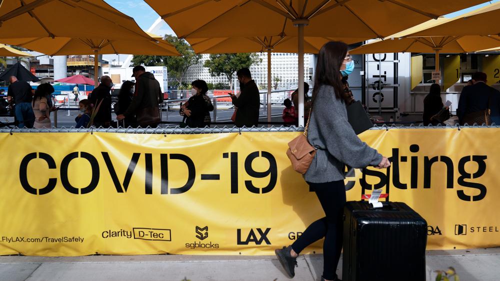 Travelers wait in line to get tested for COVID-19 at Los Angeles International Airport in Los Angeles, Dec. 20, 2021. (AP Photo/Jae C. Hong)