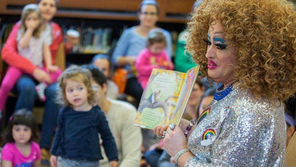 Drag queen story hours have been cropping up in community libraries in recent years like this one in 2017 in Brooklyn, N.Y.  Now a major health insurer has featured a drag queen event with kids in a TV commercial. (AP Photo)