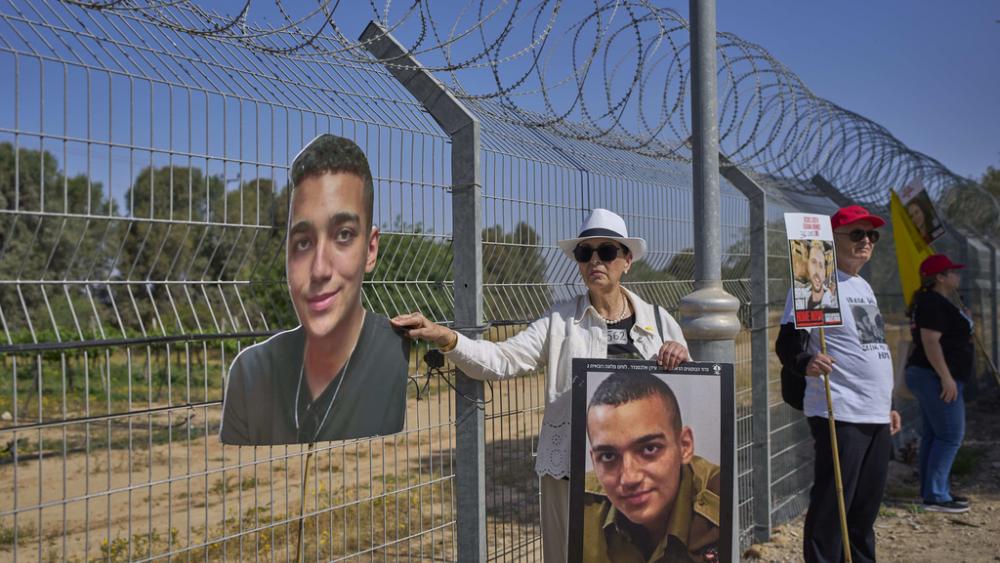 Varda Ben Baruch, holding a picture of her grandson Edan Alexander who is held hostage in Gaza, joins other families near the Gaza border in Kibbutz Nir Oz, southern Israel, April 20, 2025. (AP Photo/Ohad Zwigenberg )