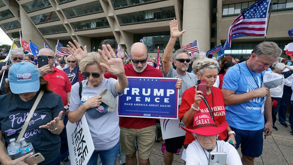 Supporters of President Donald Trump pray during a rally in front of City Hall in Dallas, Saturday, Nov. 14, 2020. (AP Photo/LM Otero)