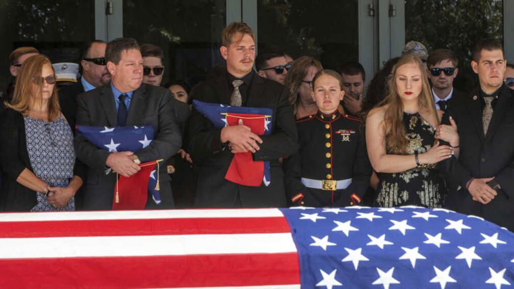 After the service for fallen Marine Sgt. Nicole Gee, her father Richard Herrera, left, and husband Jarod Gee hold U.S. flags at Bayside Church&#039;s Adventure Campus in Roseville, CA, Sept. 18, 2021 (Renee C. Byer/The Sacramento Bee via AP)