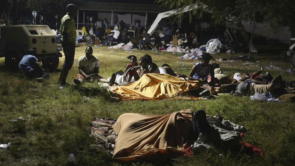 People displaced from their earthquake destroyed homes spend the night outdoors in a grassy area that is part of a hospital in Les Cayes, Haiti. (AP Photo/Joseph Odelyn)