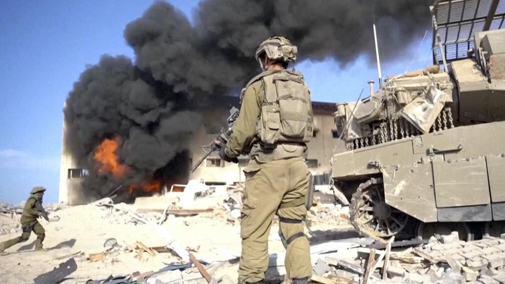 Image taken from a video released by the Israeli Defense Forces on Nov. 14, 2023. An Israeli soldier holds a weapon in Gaza City.  (Israel Defense Forces via AP)
