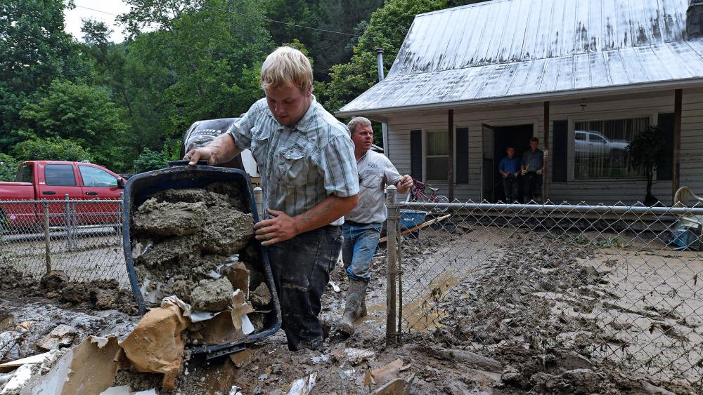 Volunteers from the local mennonite community clean flood damaged property from a house at Ogden Hollar in Hindman, Ky., Saturday, July 30, 2022. (AP Photo/Timothy D. Easley)