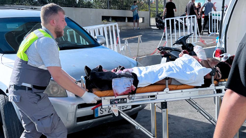 A Civil Defense first-responder carries a wounded man whose handheld pager exploded at al-Zahraa hospital in Beirut, Lebanon, Tuesday, Sept. 17, 2024. (AP Photo/Hussein Malla)