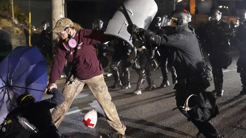 A Portland police officer shoves a protester as police try to disperse the crowd. (AP Photo/Nathan Howard)