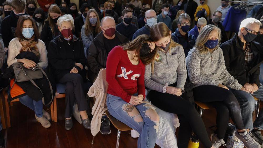 A woman leans on a friend during a prayer vigil at Carroll University in Waukesha, Wis., Monday, Nov. 22, 2021, after an SUV plowed into a Sunday Christmas parade, killing several and injuring dozens of others. (AP Photo/Jeffrey Phelps)