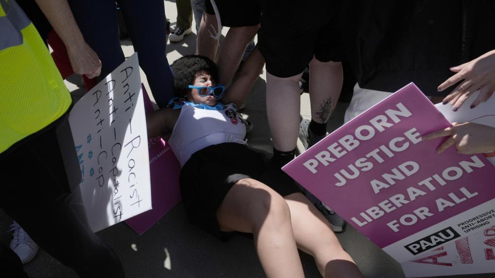 An pro-life protestor is seen on the ground after being pushed during a protest by abortion activists at the Supreme Court, June 24, 2024. (AP Photo/Alex Brandon)