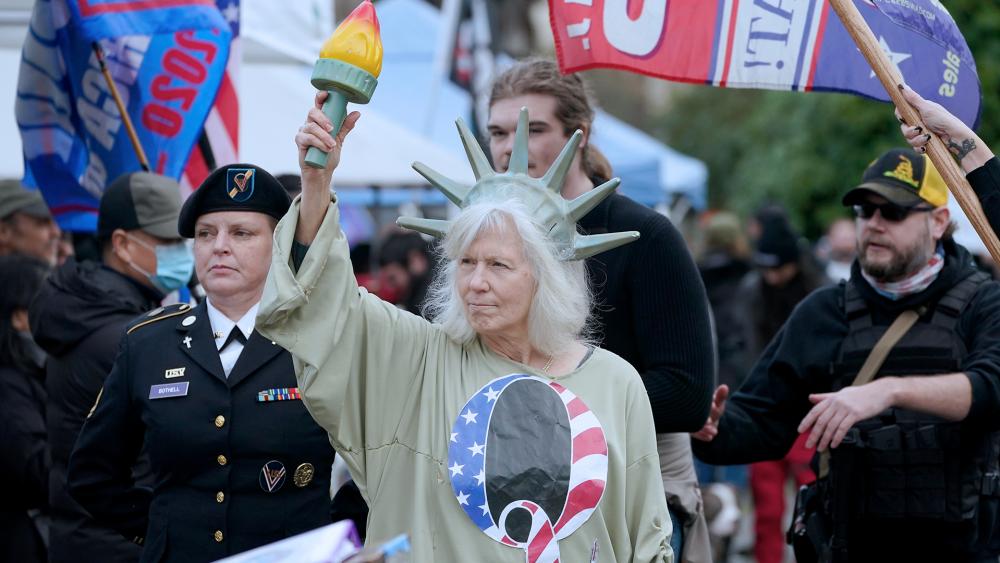 A person dressed as Lady Liberty wears a shirt with the letter Q, referring to QAnon, at a protest, Jan. 6, 2021, at the Capitol in Olympia, Wash. (AP Photo/Ted S. Warren)