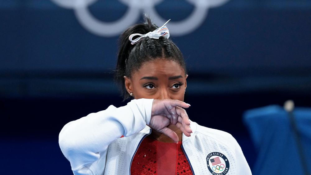 US gymnastic star Simone Biles watches gymnasts perform after an apparent injury, at the 2020 Summer Olympics, Tuesday, July 27, 2021, in Tokyo. Biles withdrew from the team finals. (AP Photo/Ashley Landis)