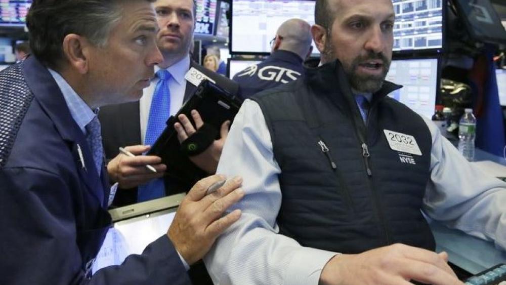 Specialist James Denario, right, works with traders on the floor of the New York Stock Exchange. (AP Photo)