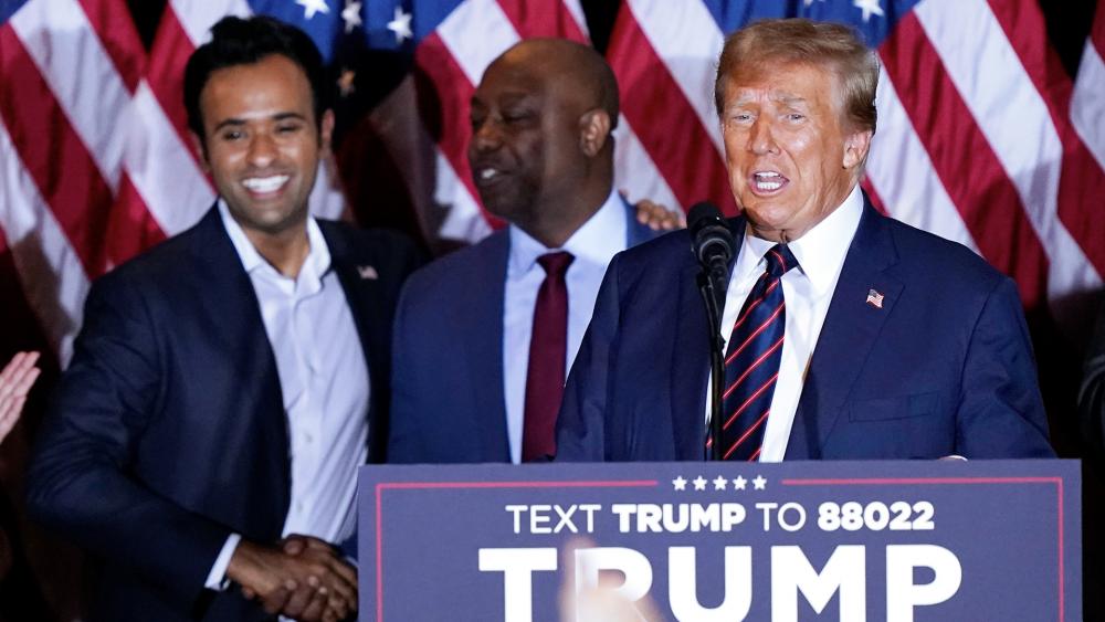 Republican presidential candidate former President Donald Trump as Sen. Tim Scott, R-S.C., and Vivek Ramaswamy watch at a primary election night party in Nashua, N.H., Tuesday, Jan. 23, 2024. (AP Photo/Pablo Martinez Monsivais)