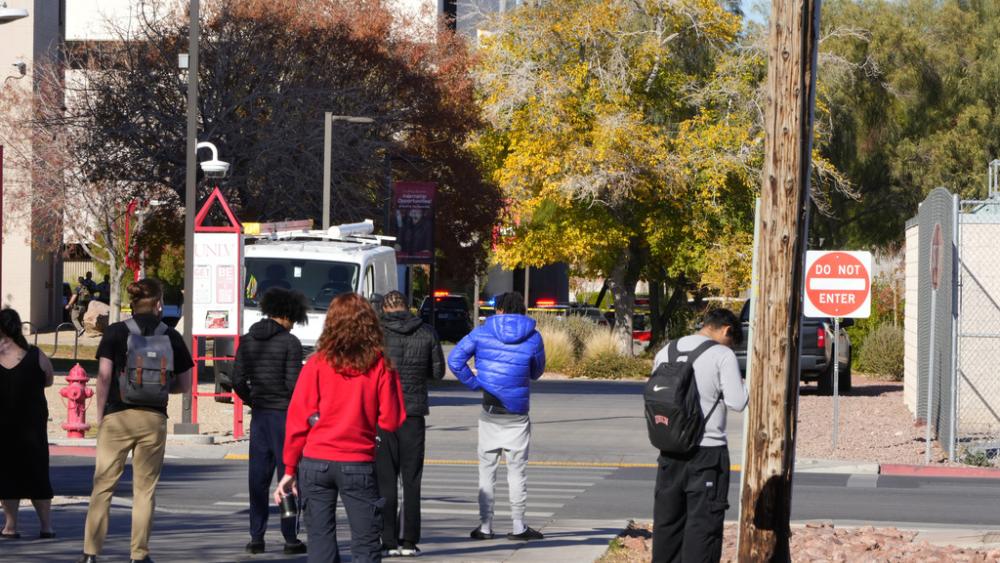 University of Nevada, Las Vegas, students observe police activity after a shooting reported on campus, Wednesday, Dec. 6, 2023, in Las Vegas. (AP Photo/Lucas Peltier)