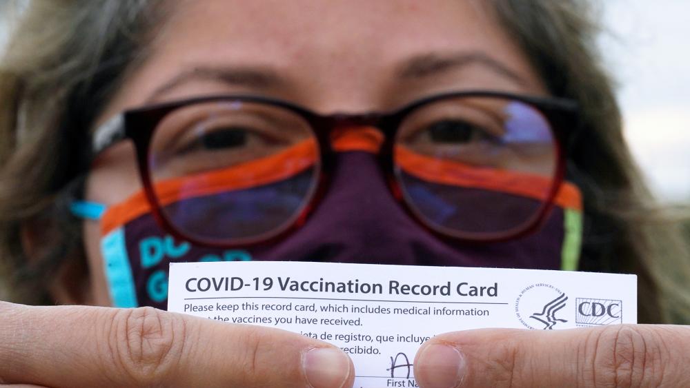 A woman poses with her vaccination card after getting her second Moderna COVID-19 shot  (AP Photo/David J. Phillip)