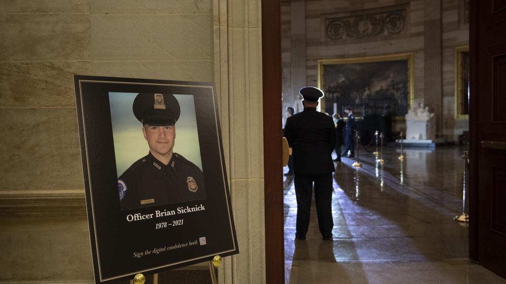 FILE - In this Feb. 2, 2021, file photo a placard is displayed with an image of the late U.S. Capitol Police officer Brian Sicknick.  (Brendan Smialowski/Pool via AP, File)