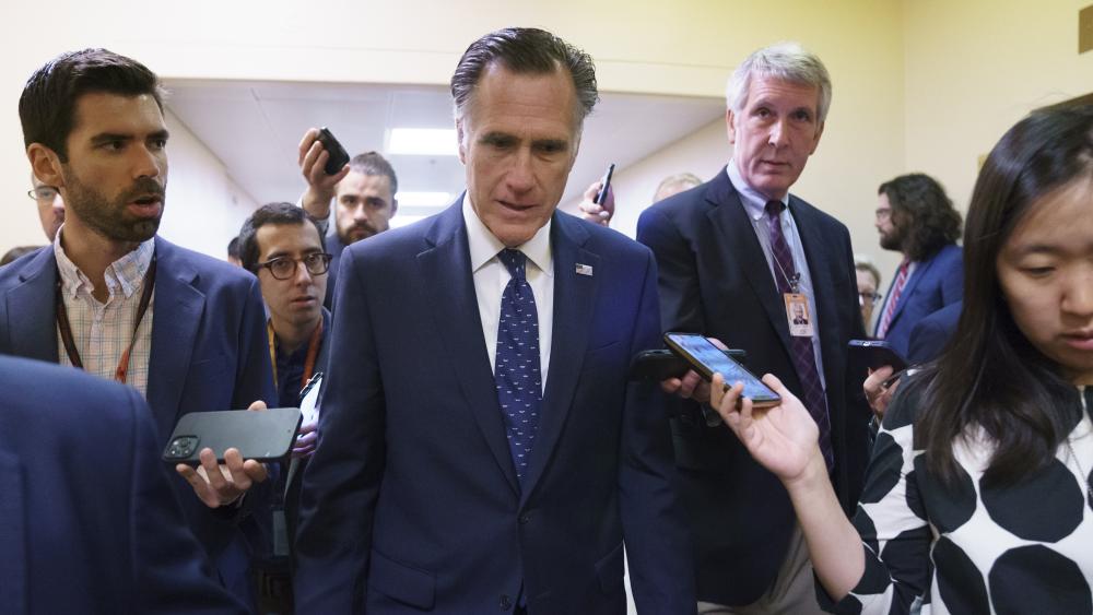 Sen. Mitt Romney, R-Utah, is surrounded by reporters as he walks to the Senate chamber on Thursday, June 10, 2021. Sen. Romney is working with a bipartisan group of senators seeking to pass an infrastructure deal. AP