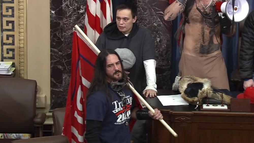 In this file image from U.S. Capitol Police video, Paul Allard Hodgkins, 38, of Tampa, Fla., front, stands in the well on the floor of the U.S. Senate on Jan. 6, 2021, at the Capitol in Washington. (U.S. Capitol Police via AP, File)
