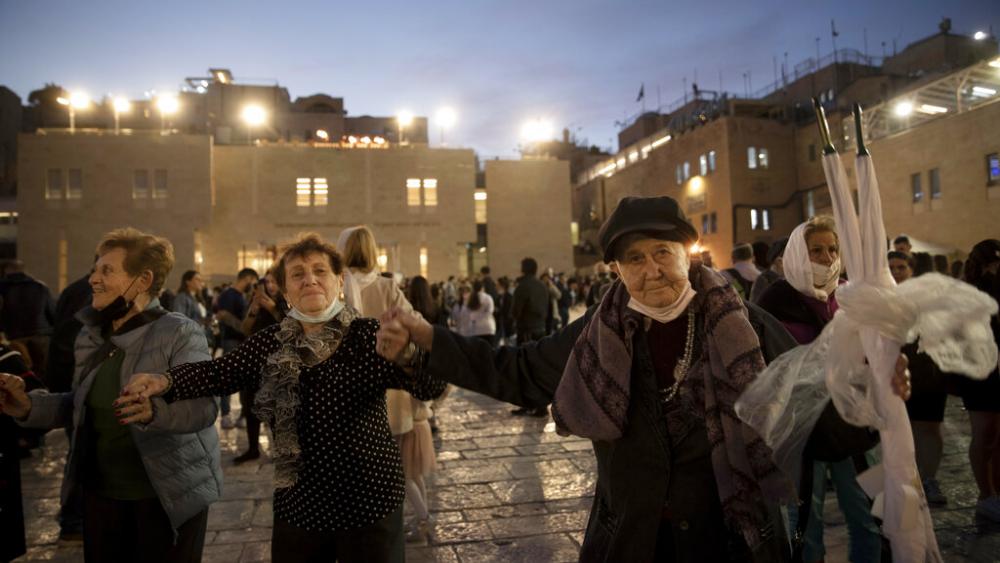Holocaust survivors dance during a Hanukkah menorah lighting ceremony at the Western Wall, in the Old City of Jerusalem, Tuesday, Nov. 30, 2021. (AP Photo)