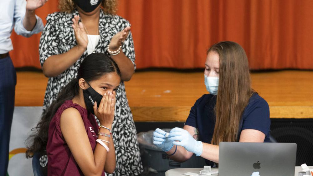 Ariel Quero, 16, left, a student at Lehman High School, reacts after getting the Pfizer COVID-19 vaccine from Katrina Taormina, right, July 27, 2021, in New York.  (AP Photo/Mark Lennihan, file)