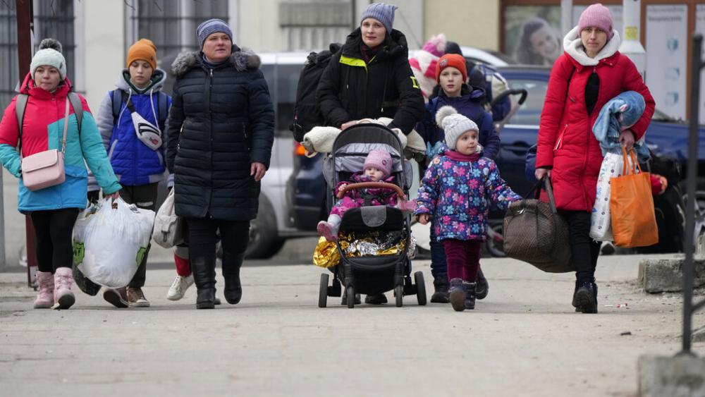 Women and children, fleeing from Ukraine, arrive on the platform of the train station in Przemysl, Poland, after disembarking from a bus which traveled from the border, Tuesday, March 8, 2022. (AP Photo)