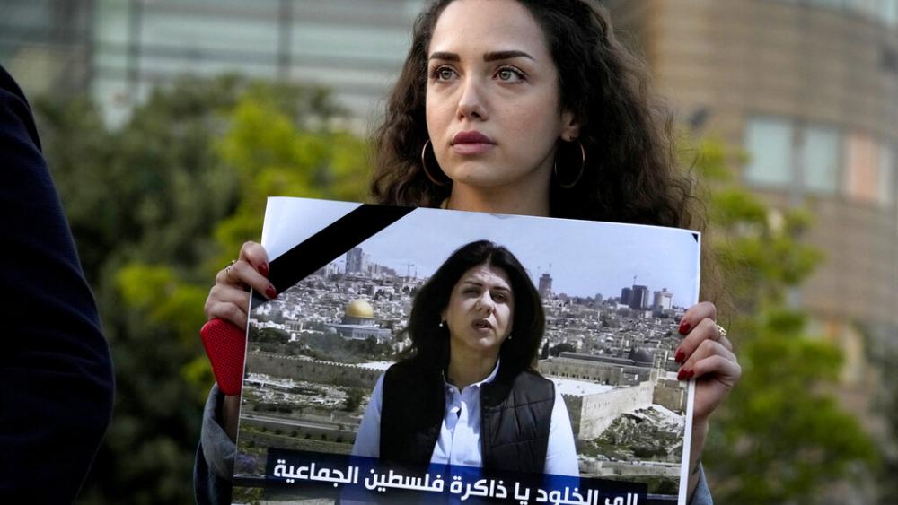 A Lebanese journalist holds a portrait of Al Jazeera journalist Shireen Abu Akleh during a protest in front of United Nations headquarters in Beirut, Lebanon, Wednesday, May 11, 2022. (AP Photo)