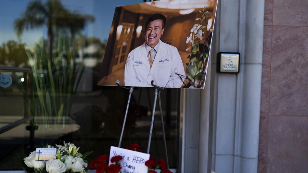 A photo of Dr. John Cheng, a 52-year-old victim who was killed in Sunday&#039;s shooting at Geneva Presbyterian Church, is displayed outside his office in Aliso Viejo, Calif., Monday, May 16, 2022. (AP Photo)
