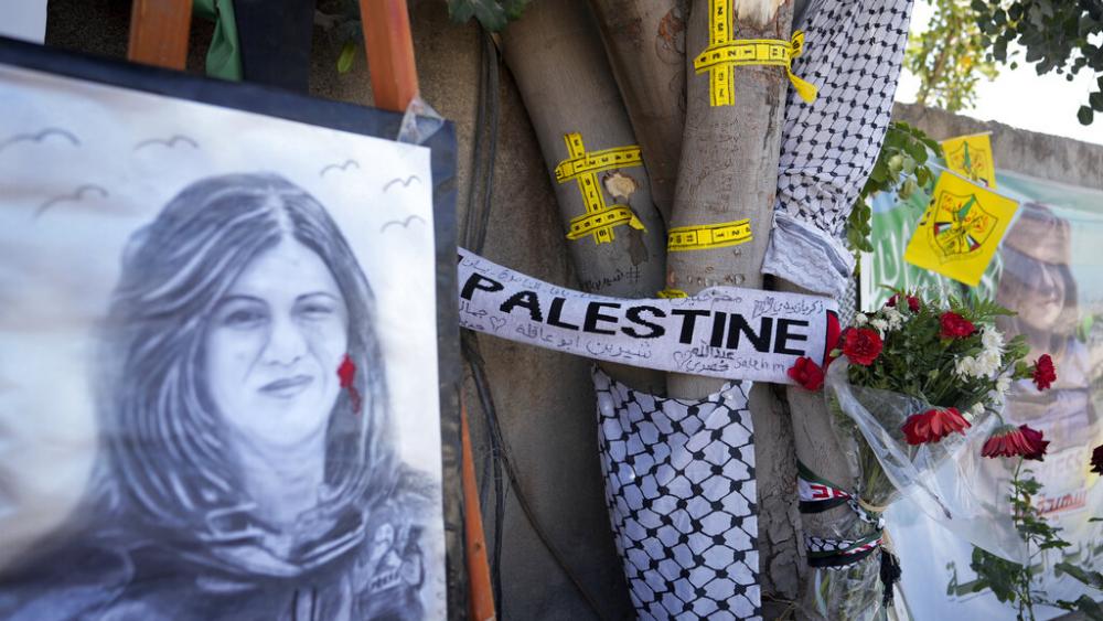 Yellow tape marks bullet holes on a tree and a portrait and flowers create a makeshift memorial at the site where Palestinian-American Al-Jazeera journalist Shireen Abu Akleh was shot and killed. (AP Photo)