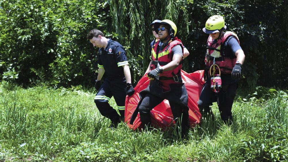Rescuers carry the body of a flood victim that was retrieved from the Jukskei river in Johannesburg, Dec. 4, 2022. (AP Photo)