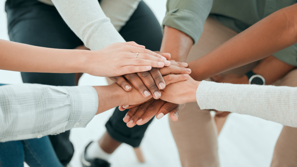 group of people with one hand each in the center together