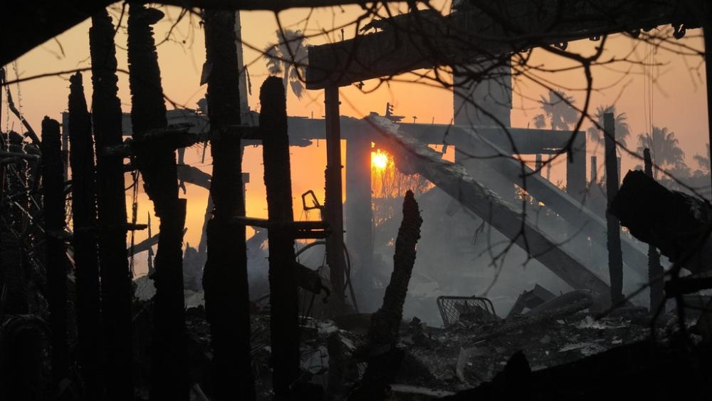 The sun rises and destruction from the Palisades Fire is seen in the Pacific Palisades neighborhood of Los Angeles, Thursday, Jan. 9, 2025. (AP Photo/Damian Dovarganes)