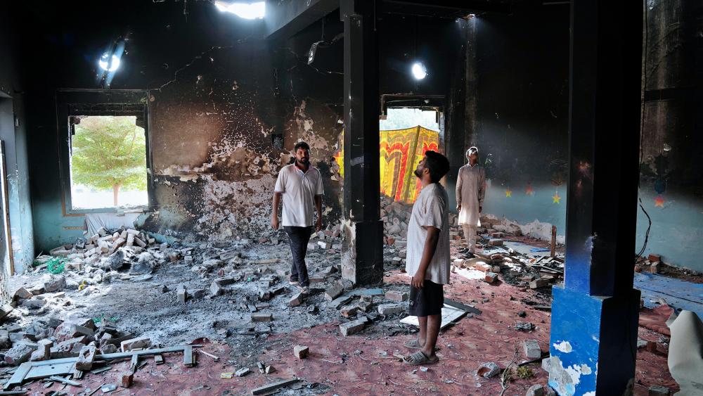Christians stand inside a church building torched by angry Muslim mob in Jaranwala near Faisalabad, Pakistan, Aug. 17, 2023. (AP Photo/K.M. Chaudary)