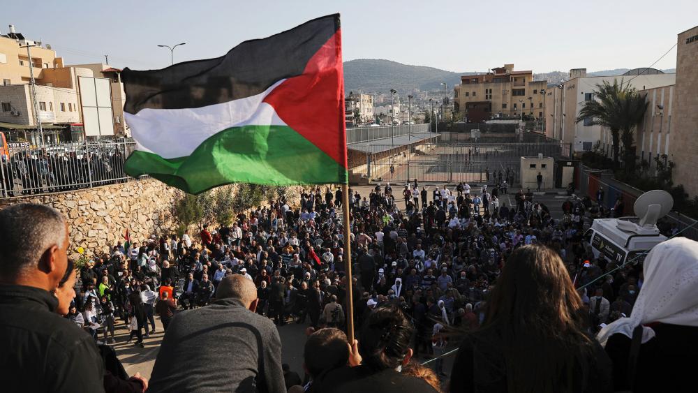 A Palestinian flag flies over the annual Land Day rally in the Arab city of Arraba, northern Israel, Tuesday, March 30, 2021. (AP Photo/Mahmoud Illean)